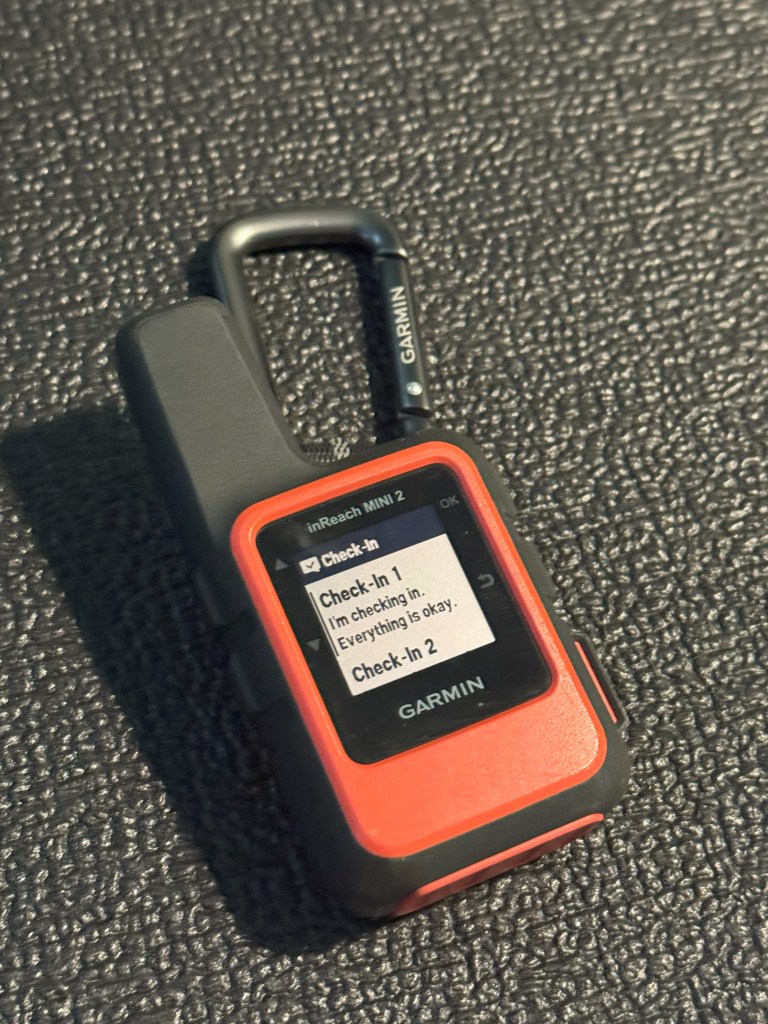 A Garmin InReach displays an option to check in.