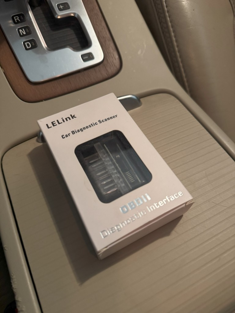 An OBD dongle sits on a center console.