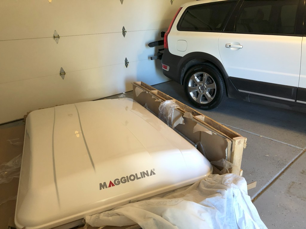 A rooftop tent sits on a garage floor. 