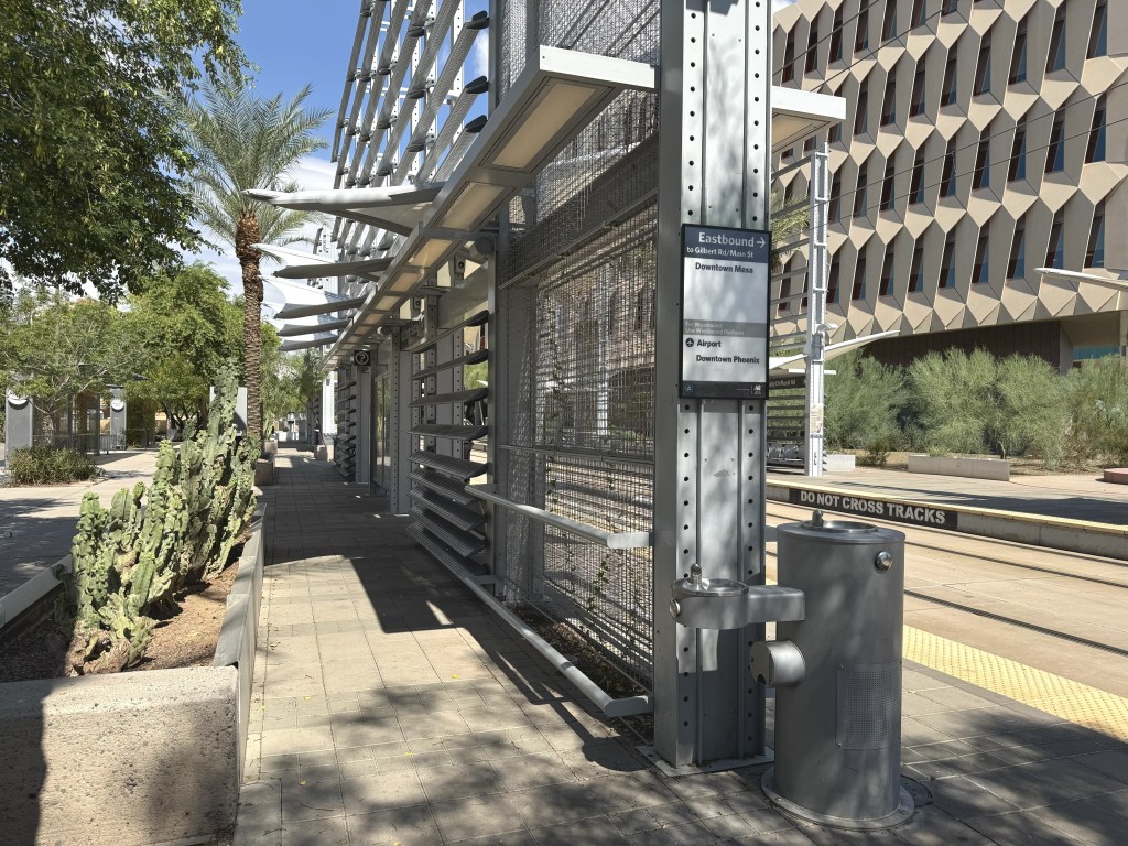 A light rail station with palm trees and great architecture.
