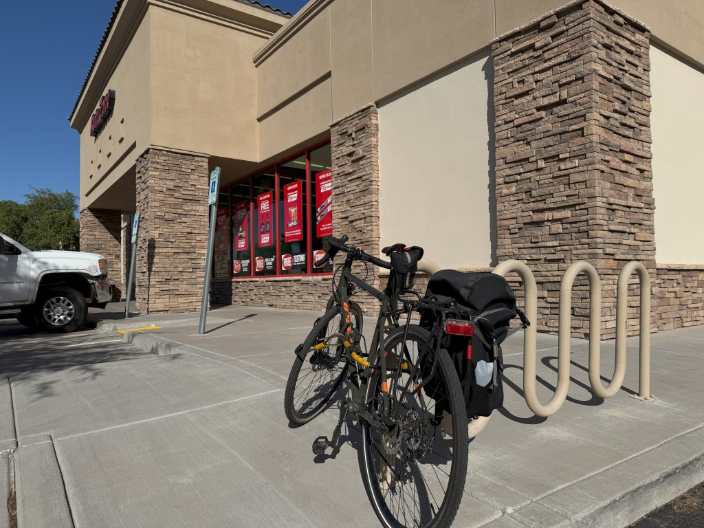 A bicycle outside of an auto supply store.