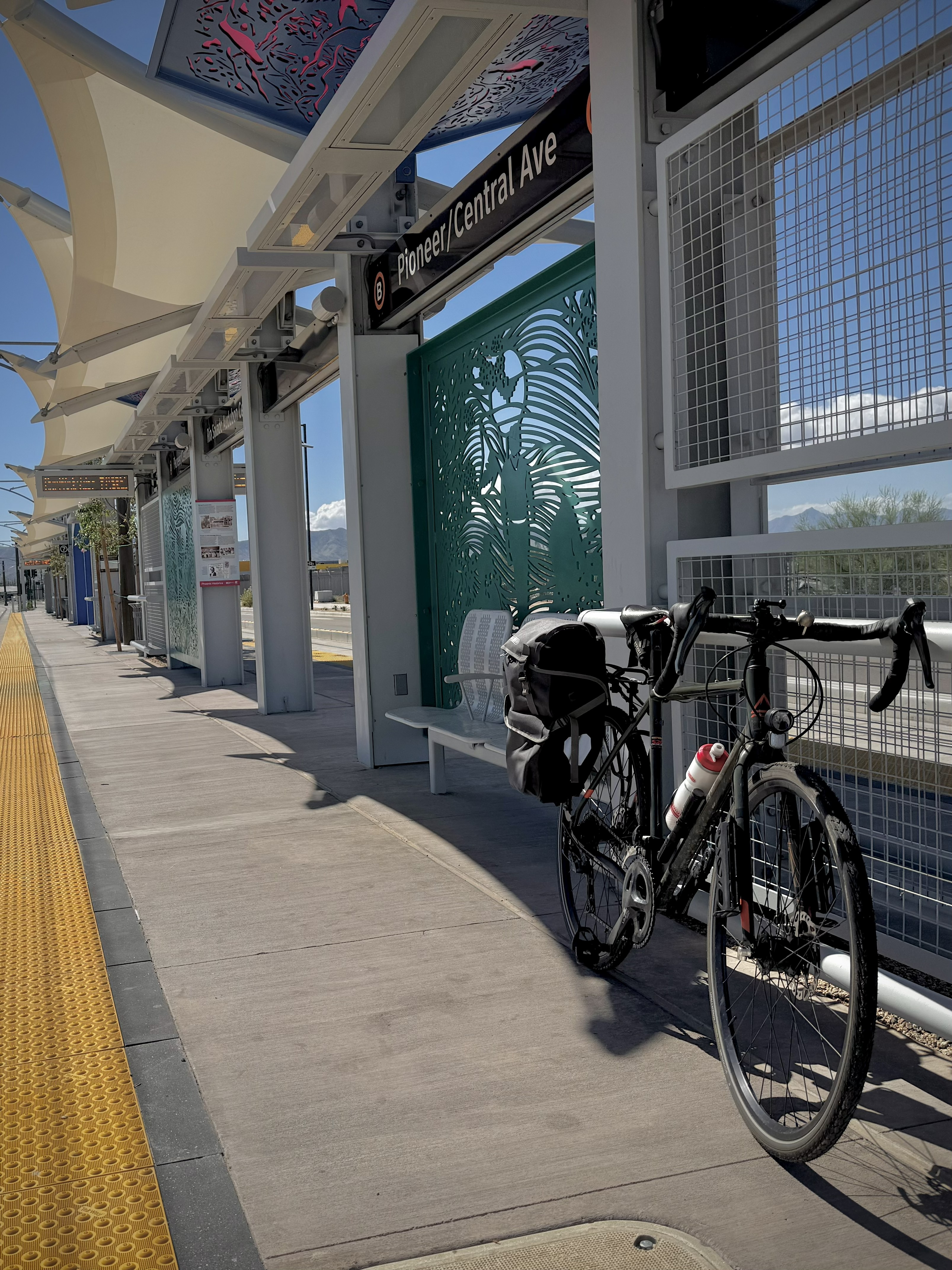 A bicycle leans against a wall at a light rail station