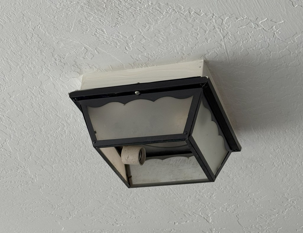 A 1980's light fixture on a ceiling.