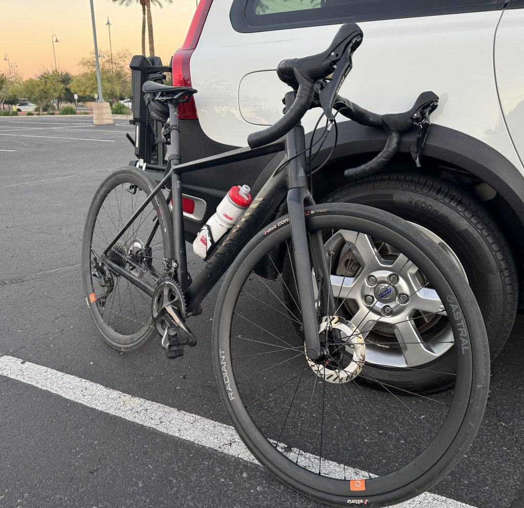 A road bike leans against a car