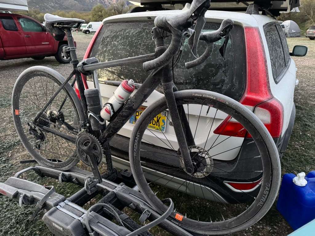 A road bike on the back of a vehicle covered in frost.
