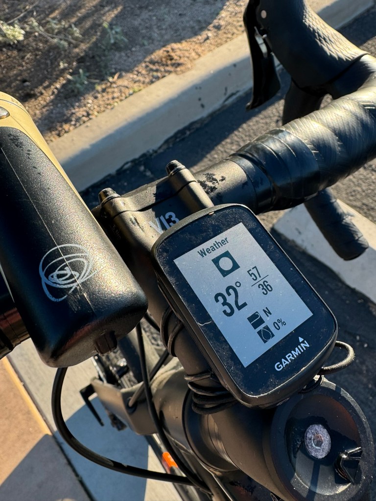 A Garmin bicycle GPS displays 32 degrees.