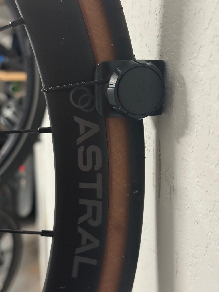 A close up view of a bike wheel secured to a wall with a wall mount.
