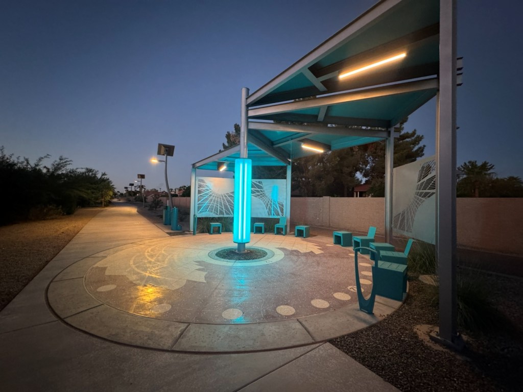 A rest area along a multiuse pathway in Tempe glows beneath LED lighting as the sun rises.