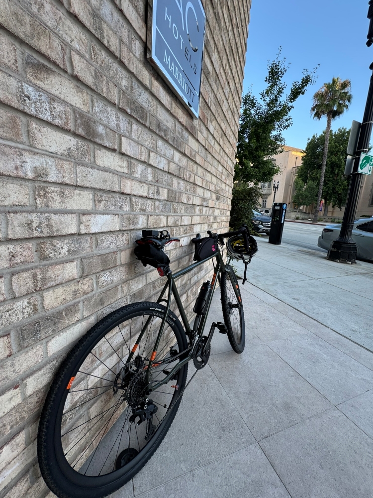 A bicycle leans against a hotel wall