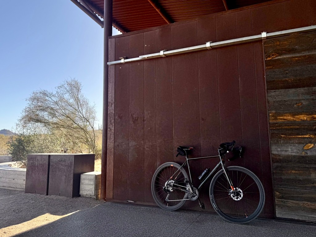 A gravel bike leans against an architectural trailhead in Scottsdale, AZ