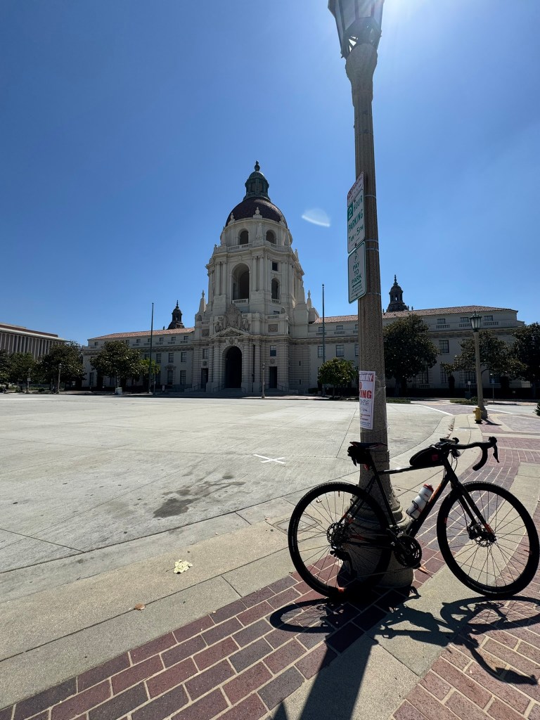A bicycle leans against a street lamp in front of Pasadena City Hall