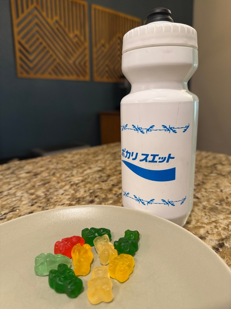 A close up photo of a water bottle and gummy bears