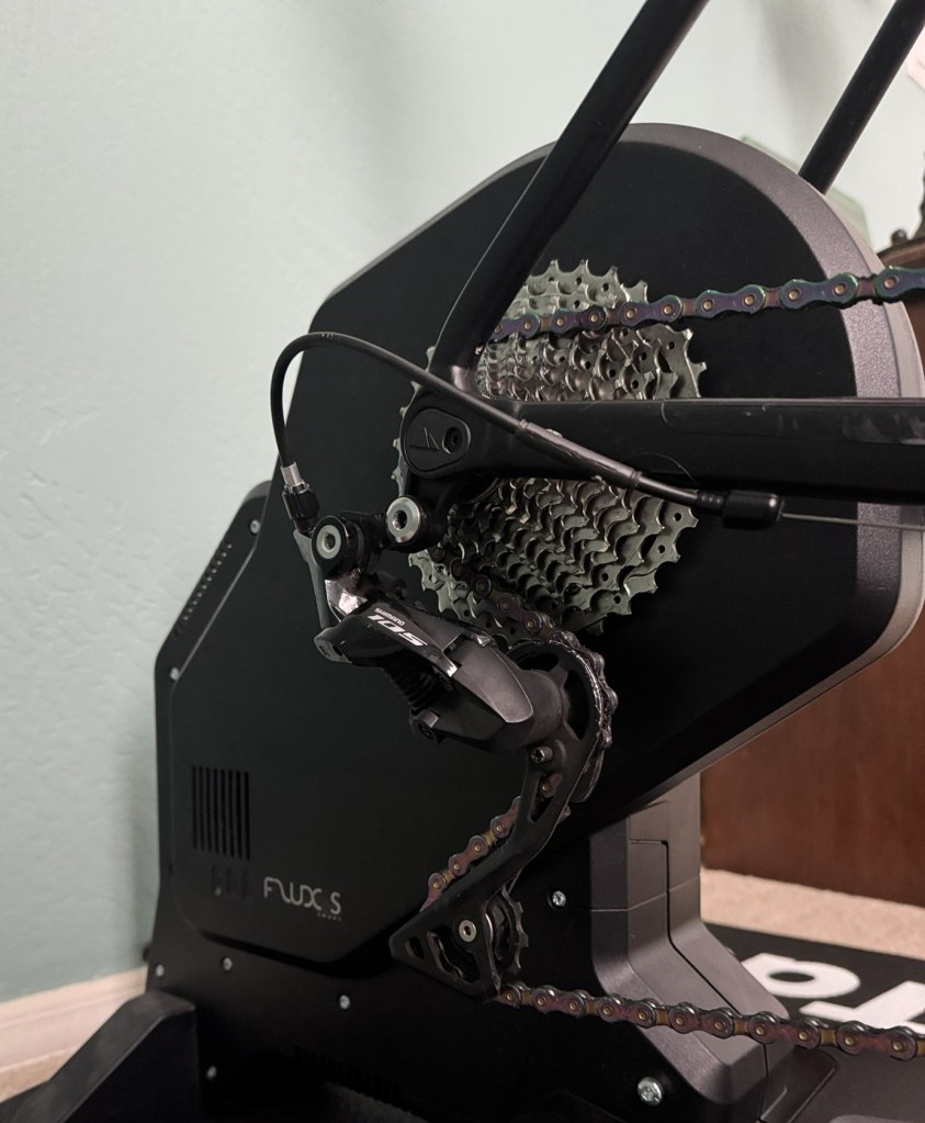 A close-up photograph of the drivetrain on a Garmin Tacx Flux S indoor trainer