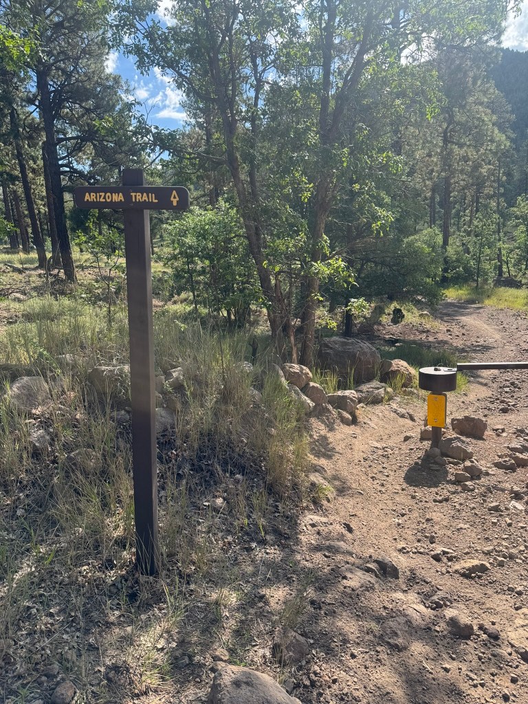 A fencepost next to a gate marks the Arizona Trail