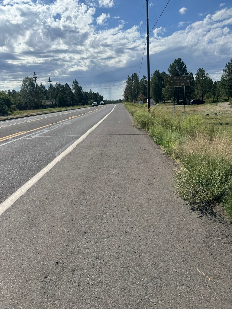 The shoulder of a two lane highway from a bicyclist's perspective.