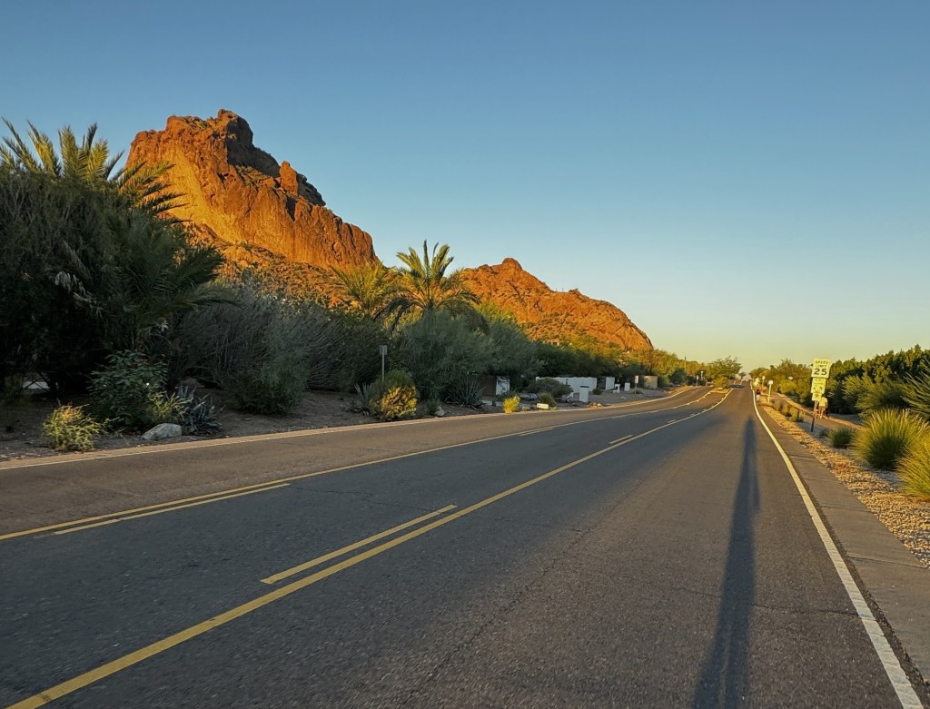 Bicycling along a road with Camelback Mountain in the distance