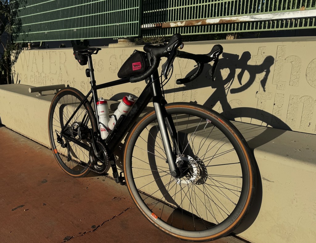 A road bike leans against a wall.
